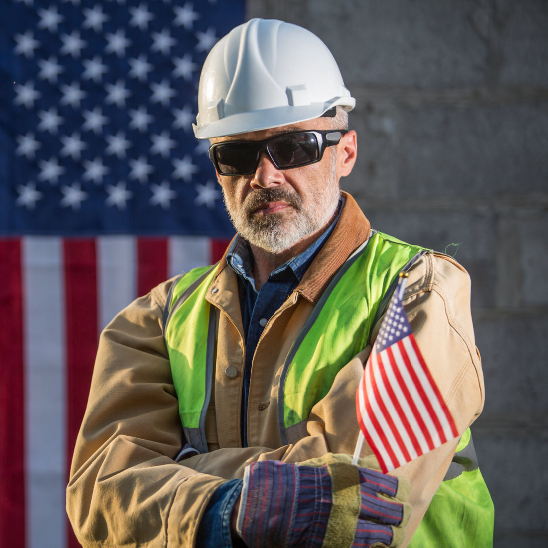 Worker holding an American flag celebrating labor day