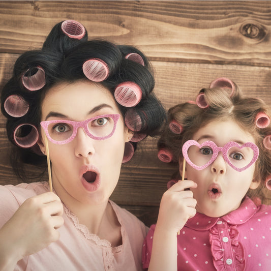 Picture of a mother and daughter in curlers making funny faces and having a fun time on mother's day. Shop local mother's day gifts at LocalWe.