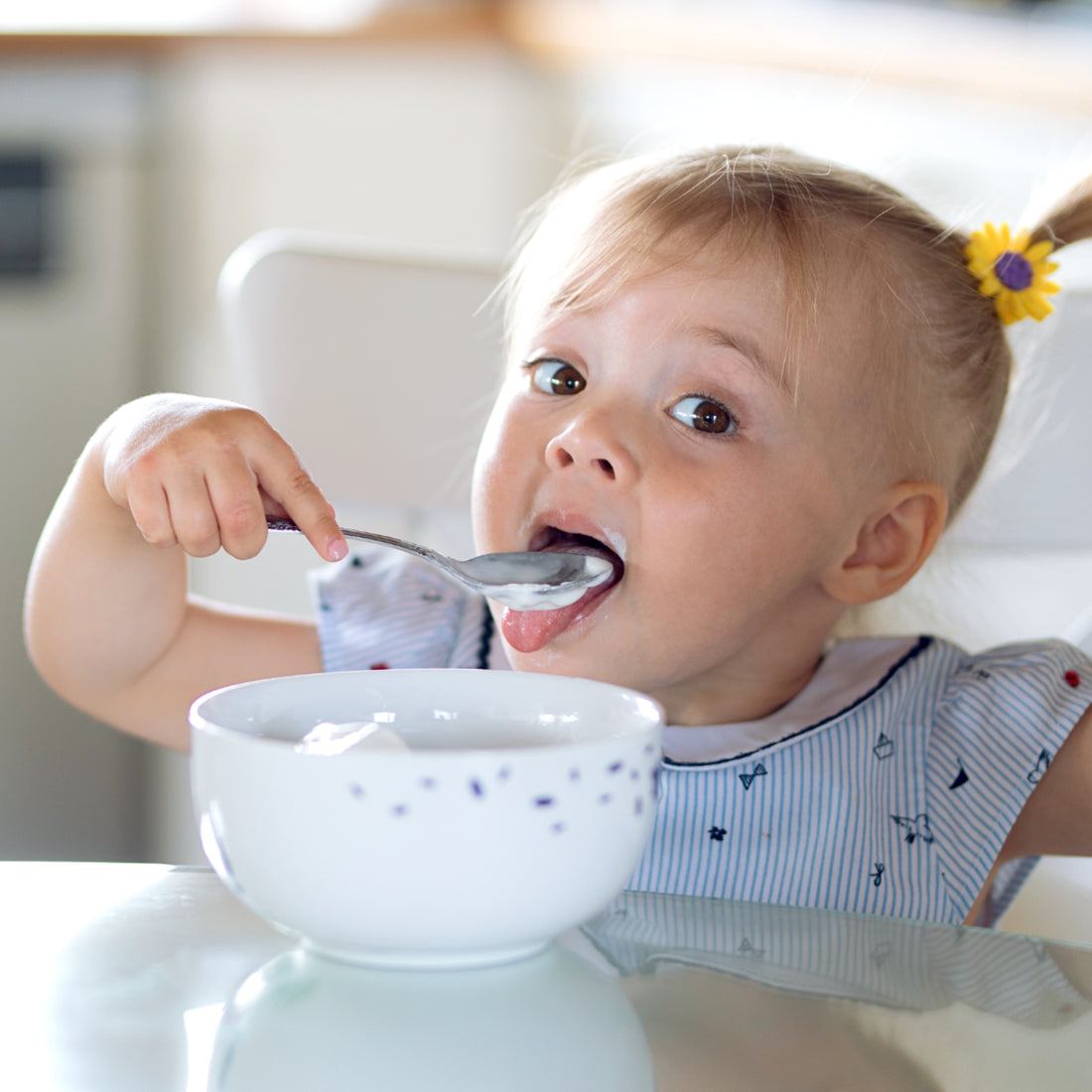 Cute little girl eating with a spoon