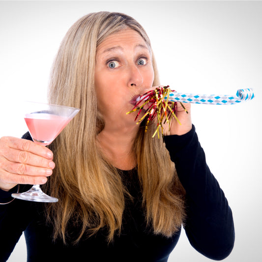 Woman holding a cosmo martini and blowing a noisemaker to celebrate women's history month